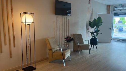 a living room with chairs and a floor lamp at Hotel La Basílica in Venta de Baños