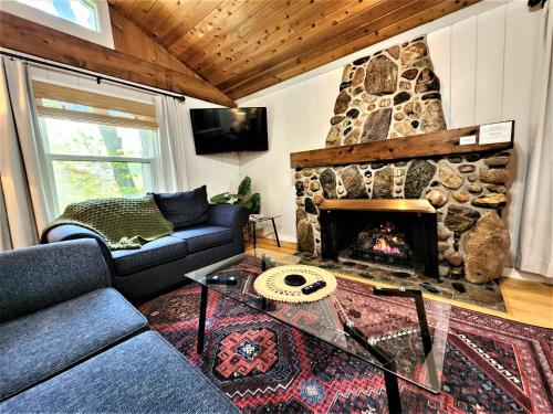 a living room with a couch and a stone fireplace at Steps to Beach-Hot Tub-Fireplace-Northern Original in Traverse City