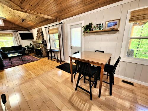 a dining room and living room with a table and chairs at Steps to Beach-Hot Tub-Fireplace-Northern Original in Traverse City