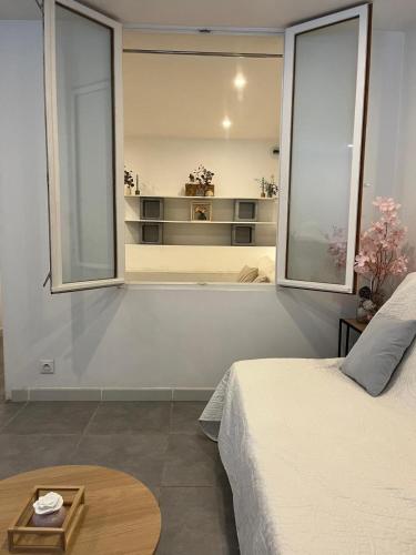 a bedroom with a bed and a large window at La Mhirabelle in Saint-Paul-de-Vence