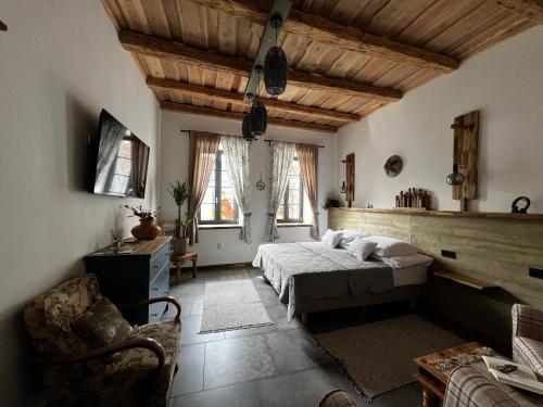 a bedroom with a bed and a couch and windows at Zöldkapu Vendégház in Balassagyarmat