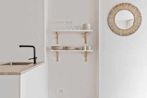 a kitchen with white walls and a mirror and a counter at Studio Petite Plage in Ostend