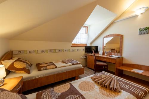 - une chambre avec 2 lits, un bureau et un miroir dans l'établissement Szenti Vendégház, à Győr