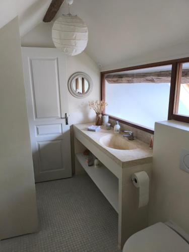 une salle de bain avec un lavabo et une fenêtre dans l'établissement Belle Maison dans corps de ferme - logement Gabriel, à Villiers-sous-Grez