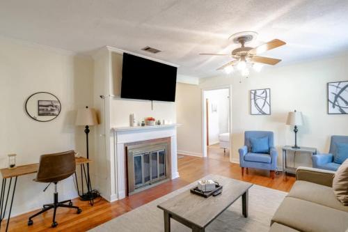 a living room with a fireplace and a flat screen tv at Close to Midtown & Parks - Little Blue in Mobile