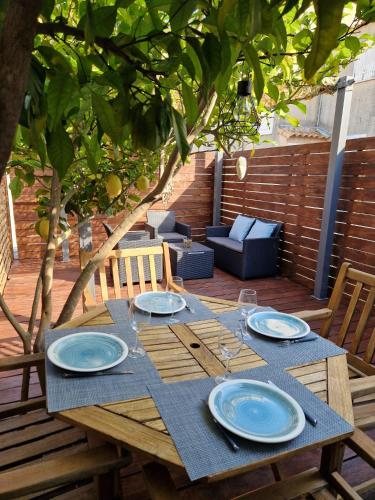 une table en bois avec des plaques bleues au-dessus dans l'établissement Villa Club Stell Bandol - 2 à 6 personnes, à Bandol