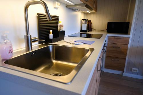 a kitchen with a stainless steel sink in a kitchen at Koselig leilighet i Grimstad like ved UiA in Grimstad