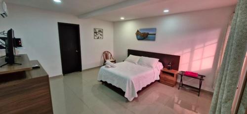 a bedroom with a bed and a television in it at Hostal Marlyn in San Andrés