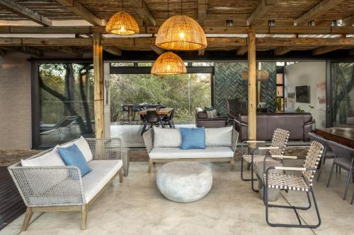 an outdoor patio with chairs and a table and a tableablish at Rixile Kruger Lodge in Skukuza