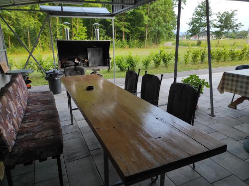 a wooden table and chairs in a patio at Vikendica Ninic in Laktaši
