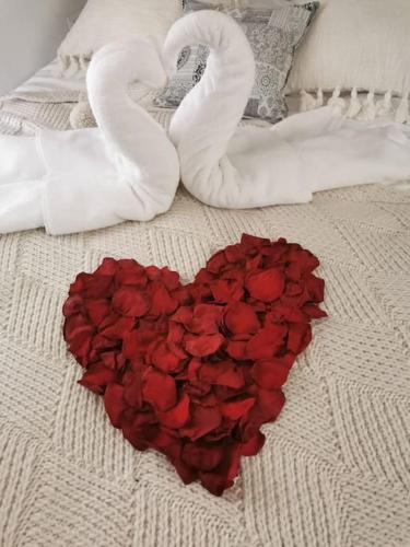un groupe de roses et deux cœurs sur un lit dans l'établissement La petite maison dans les nuages, à Tourtour