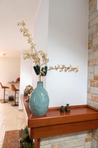 a blue vase sitting on a table with flowers in it at Stanze di Puglia in Sannicandro di Bari