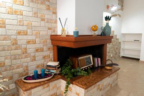a living room with a brick fireplace with a tv at Stanze di Puglia in Sannicandro di Bari