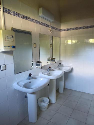a bathroom with three sinks and a large mirror at Glamping Cañon del Rio Lobos in Ucero
