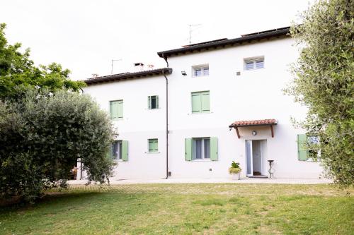 an exterior view of a white building with trees at Tenuta EnGi in Verona