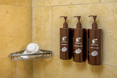 tres botellas de jabón y toallas en una pared en Knott's Hotel, en Buena Park