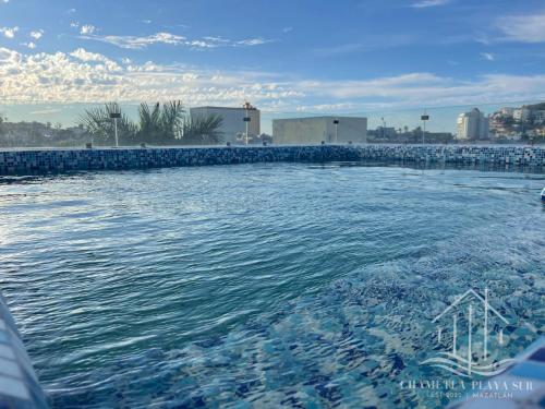 uma grande piscina com azulejos azuis na água em NewComfy~5 Area~Walk 2 Beach~Pool~Views~King Bed em Mazatlán