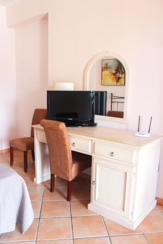a desk with a television and a mirror at Affittacamere A f r o d i t e in Lipari