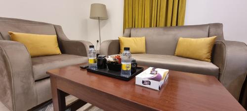 een woonkamer met 2 banken en een salontafel bij رونزا الشميسي in Riyad