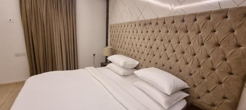 رونزا الشميسي في الرياض: غرفة نوم بسرير كبير عليها شراشف ووسائد بيضاء