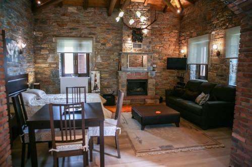 a living room with a couch and a table and a fireplace at Pacithea Villas in Miléai
