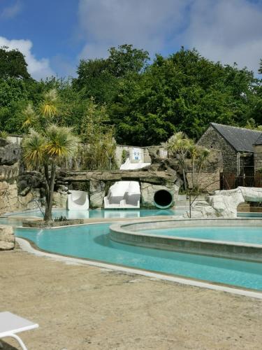 - une piscine dans une cour avec un pont dans l'établissement Mobil-home dans le calme du Domaine de Lanniron R24, à Quimper