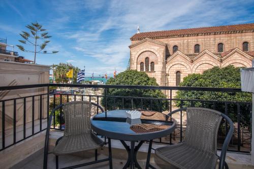a balcony with a table and chairs and a building at 5 Keys in Zakynthos Town