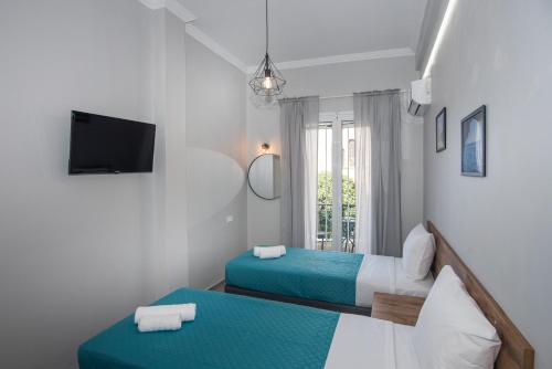 a hotel room with two beds and a tv at 5 Keys in Zakynthos Town