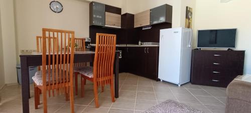 uma cozinha com uma mesa e cadeiras e um frigorífico em Europroperties Bendita Mare Apartments em Golden Sands