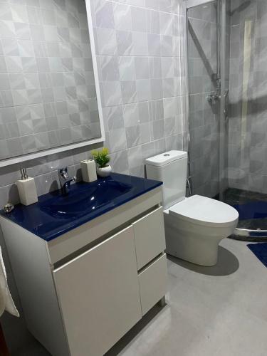 a bathroom with a blue sink and a toilet at T1 Férias Mindelo in Mindelo