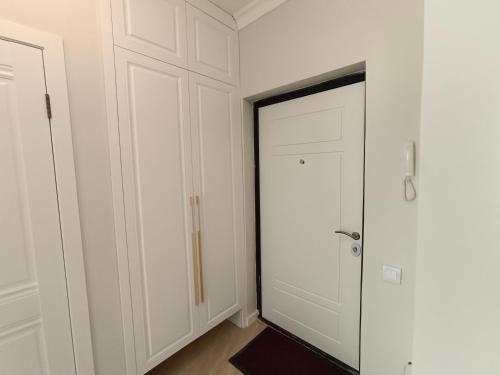 Апартаменты ЖК Сезим кала Бакыт Туран 55/12 في Taldykolʼ: خزانة بيضاء مع باب في الغرفة