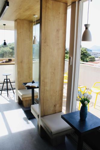 a room with tables and chairs and a balcony at Hostel Petra Marina in Dubrovnik