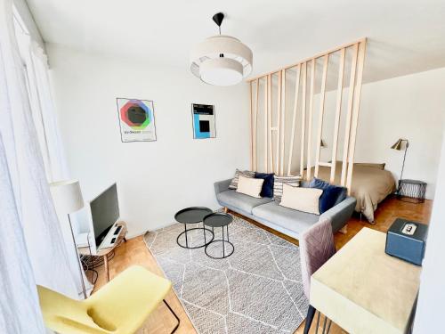 uma sala de estar com um sofá e uma televisão em Aurora Suite à Champel avec terrasse em Genebra