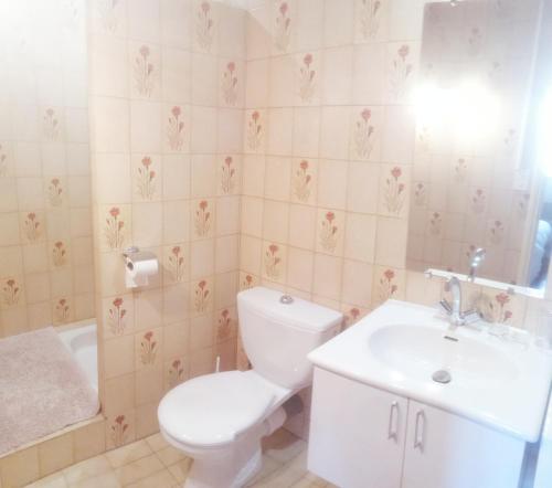 Baño blanco con aseo y lavamanos en Fleur, en Salles-Curan