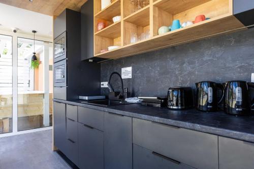 a kitchen with a black counter top and wooden cabinets at Hostel Petra Marina in Dubrovnik