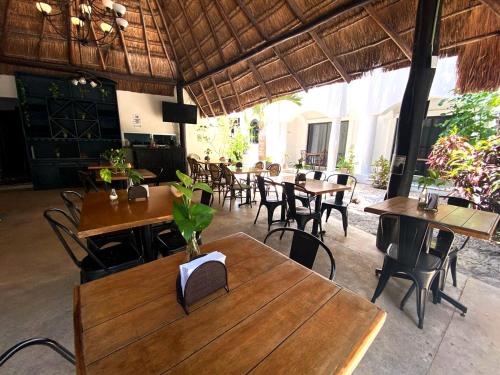 een restaurant met houten tafels en stoelen in een kamer bij Hacienda Paradise Hotel in Playa del Carmen