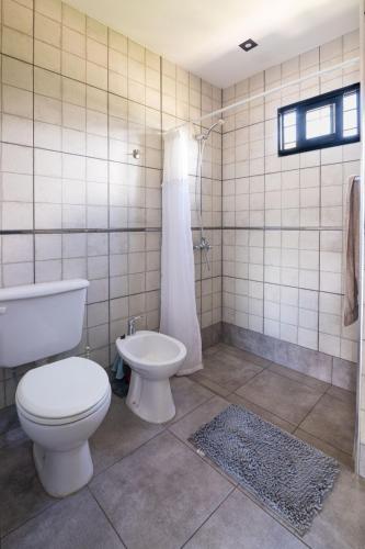 a bathroom with a toilet and a tub and a sink at La Floridita in Villa Ciudad Parque