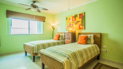 1 dormitorio con 2 camas y ventilador de techo en Margaritas Condo by BVR, en Playa del Carmen