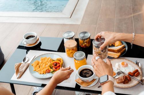 a group of people sitting at a table eating breakfast at Ennea Muses Rooms and Suites in Nafplio