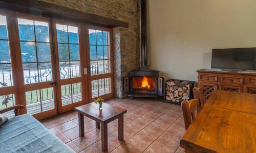 a living room with a wooden table and a fireplace at Can Tubau in Campelles