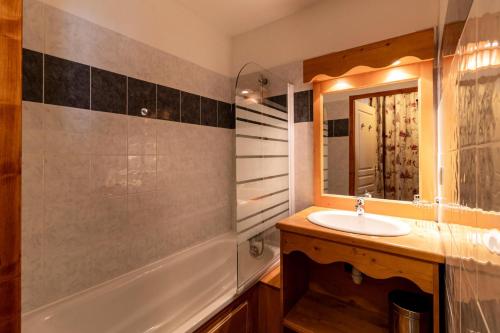 une salle de bain avec un lavabo, une baignoire et un miroir dans l'établissement Résidence Les Hauts De Preclaux - 2 pièces charmant et spacieux aux Orres 1800 MAE-5974, aux Orres