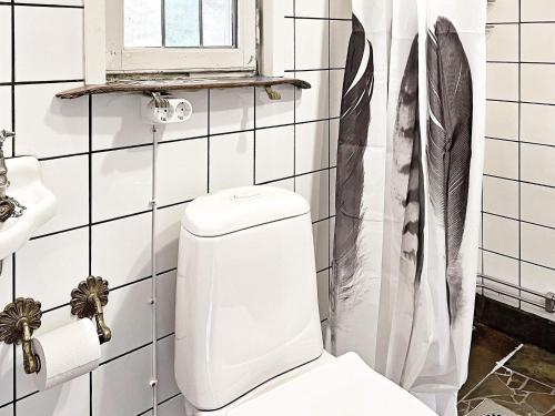 La salle de bains blanche est pourvue de toilettes et d'une fenêtre. dans l'établissement Holiday home INGARÖ V, à Grönskan