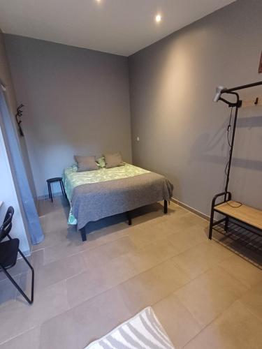 a bedroom with a bed in the corner of a room at Studio meublé tout confort climatisé in Bollène