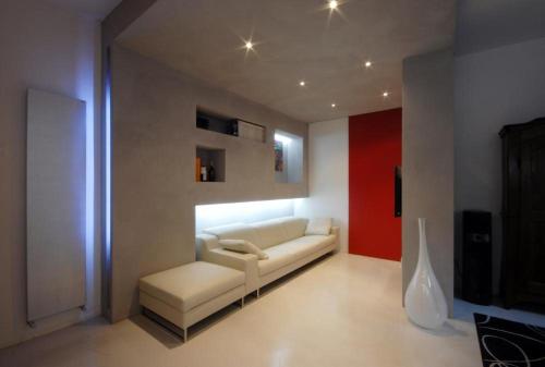 a living room with a white couch and a red wall at Lollo Apartment in Mantova