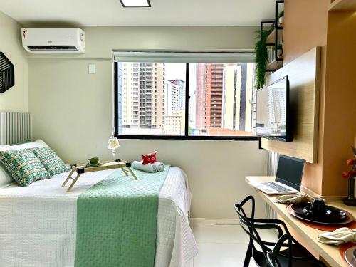a bedroom with a bed and a desk with a laptop at (108) Studio moderno - Perto da Praia in São Luís