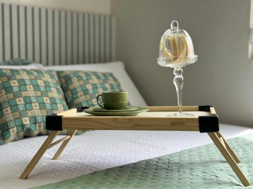 a tray with a coffee cup and a lamp on a bed at (108) Studio moderno - Perto da Praia in São Luís