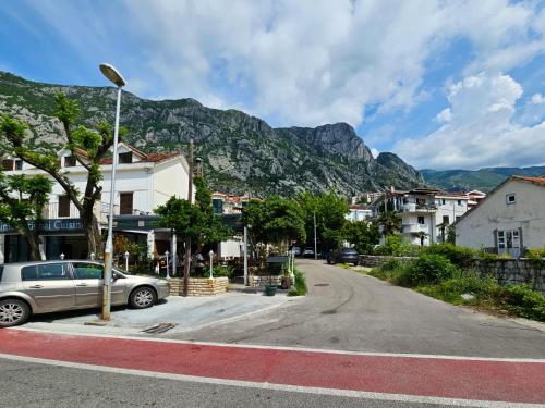 a street with a car parked in front of a mountain at Andrea Lux in Kotor