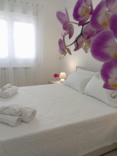 a bedroom with a white bed with towels on it at Loredana Affittacamere in Vittoria