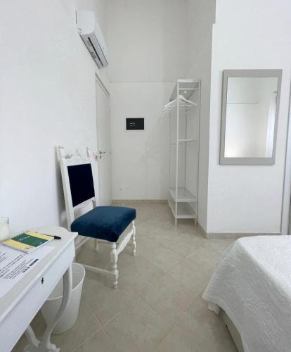 a white room with a chair and a desk at Loredana Affittacamere in Vittoria
