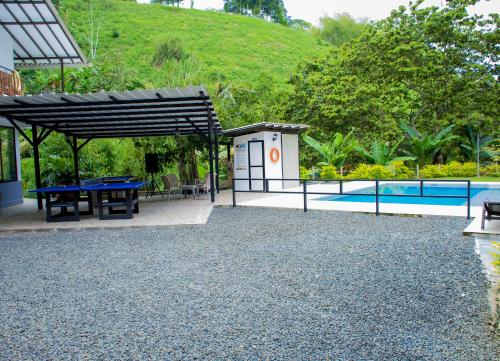un patio con mesa de picnic y piscina en FINCA CAMPESTRE EL PORVENIR, en Quimbaya